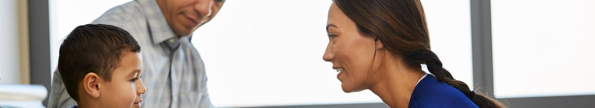 Nurse talking with pediatric patient and his dad