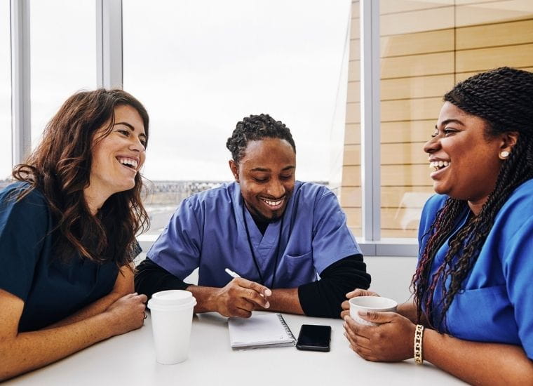 3 nurses smiling and laughing on break