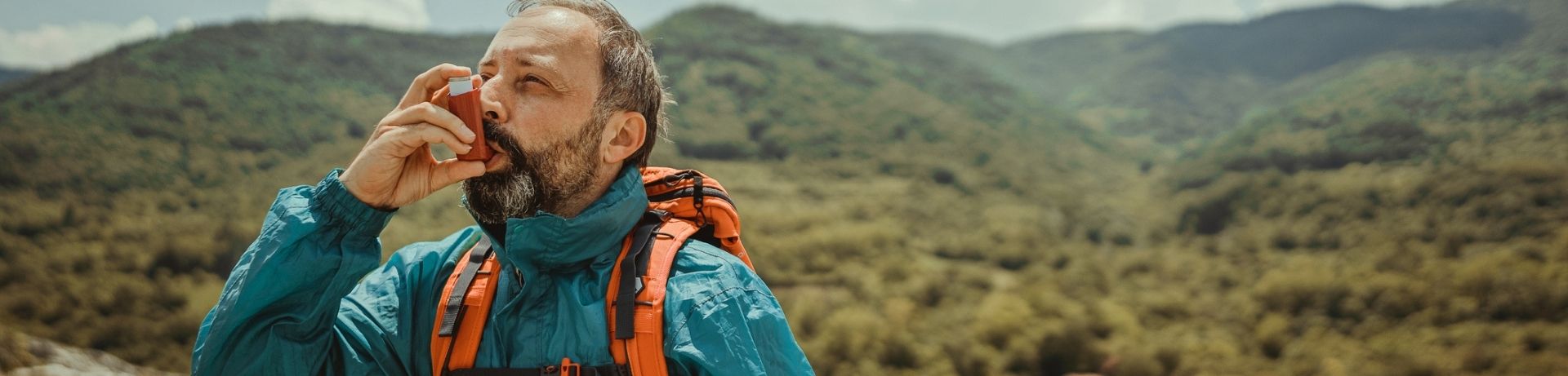 Man using inhaler on a hike